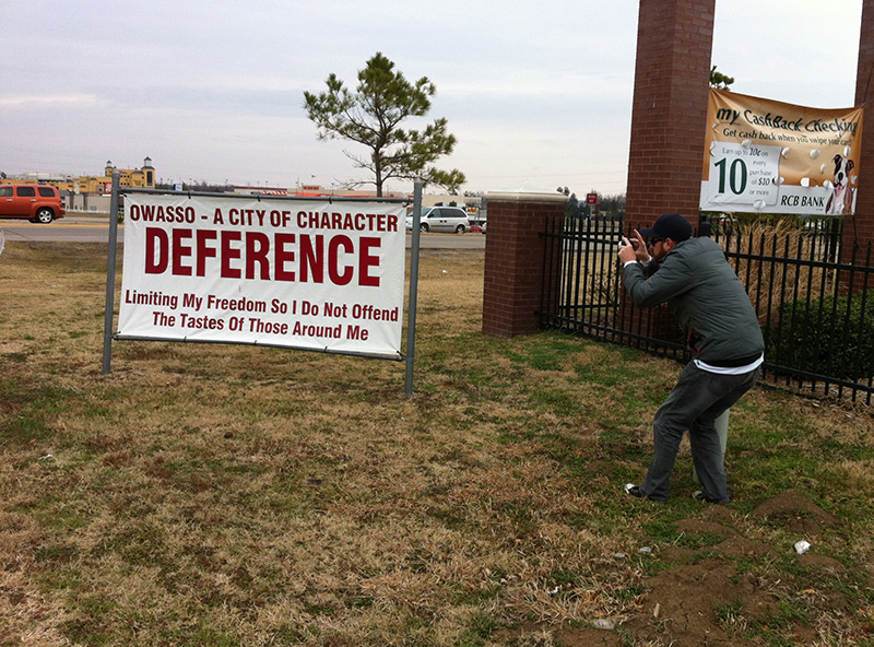 man taking a photo of a road sign