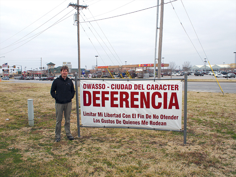 man in front of a road sign